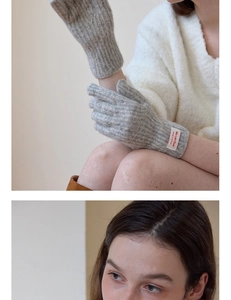 Detailed macro view of light gray ribbed knit gloves featuring a logo tag on the wrist band