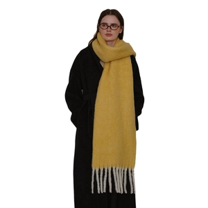 Thick yellow knitted wool scarf for women featuring chunky white tassel fringe details
