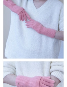 Detailed close-up of pink knit wool gloves with ribbed cuffs and small metal button accent