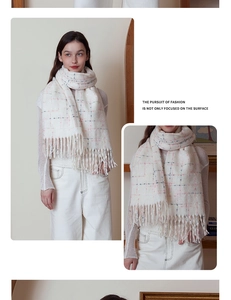 Detailed view of cream plaid cashmere-like scarf texture with delicate tassels