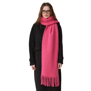 Bright pink thick wool blend tassel scarf worn with a minimalist dark winter wool coat