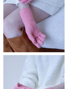 Detail of pink knitted fingerless gloves showing vertical rib pattern and wool texture