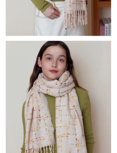 Close-up of cream plaid scarf with yellow and red stripes and soft fringe detail