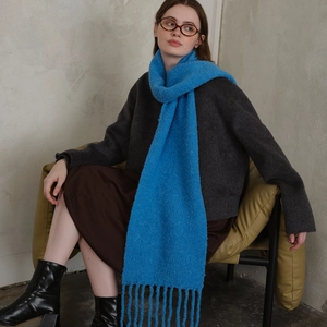 Royal blue wool blend knit scarf with long tassels, styled by a model in a warm winter look