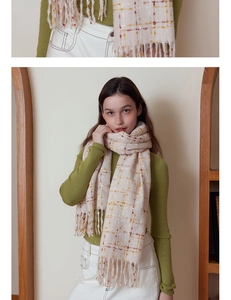 Detail showing soft cashmere-feel beige plaid scarf with fringes on a model