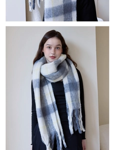 Close-up of soft plaid tassel scarf in grey and beige tones for winter warmth