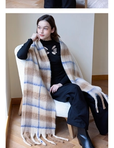 Detail of soft thick plaid scarf with classic fringe on a cozy white fleece armchair