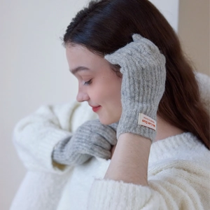 Light gray knit gloves for women featuring a ribbed texture and branded woven label