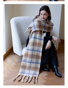 Detail of soft thick cashmere-like plaid scarf with tassels in brown and blue