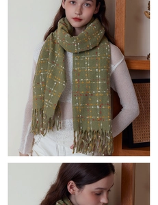 Detail shot of green plaid scarf with soft cashmere texture and long tassels on the edge