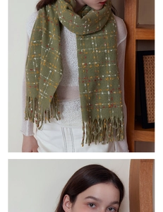 Detail of olive green plaid scarf with soft fringe and white textured knit top