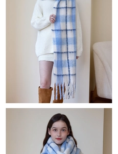 Close-up detail of soft blue and white plaid cashmere-like scarf with long fluffy tassels