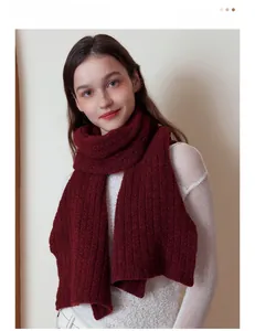 Gros plan d'une écharpe en laine rouge foncé montrant la texture en tricot côtelé