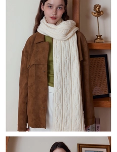 Detailed close-up of white cable knit scarf texture paired with a brown suede jacket
