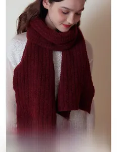 Gros plan d'une écharpe en tricot de laine bordeaux avec texture côtelée sur un mannequin
