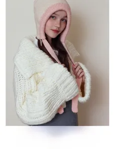 Detailed view of the chunky knit texture and soft ear flaps of the pink and white winter hat