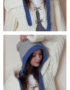 Detail of blue contrast knit trim and metal D-ring buckle on a cream hooded scarf