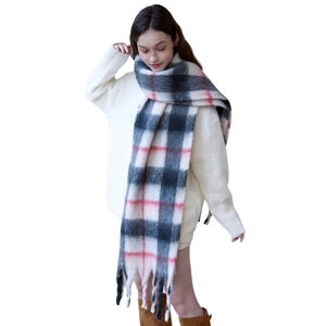 Thick black white and pink checkered scarf with long tassels shown on a model