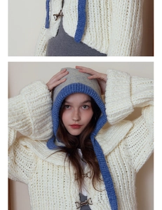 Detailed close-up of chunky knit texture and metallic hook buckle on a warm hood hat