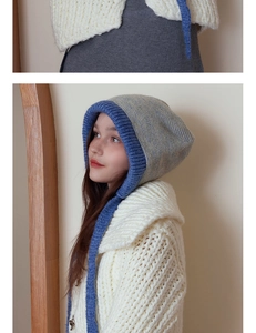 Detail of grey and blue knit hooded scarf with contrast trim and long side ties