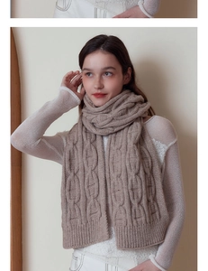 Detailed close-up of camel cable knit pattern on thick warm winter scarf