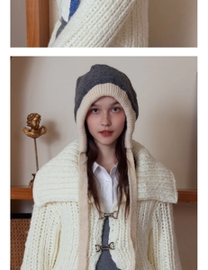 Close-up of contrast knit earflap hat and cream cardigan with metal buckle detail