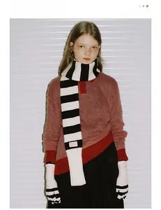 Détail de l'écharpe en tricot à rayures noires et blanches avec étiquette rose élégante