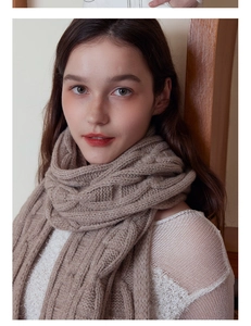 Close-up of thick cable knit texture on a soft warm winter scarf in light brown