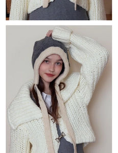 Close-up of thick cable knit texture on a winter hooded hat with contrasting colors