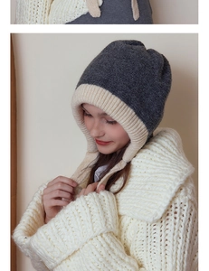 Detail of grey and white color-block knit trapper hat with chunky textured wool fabric