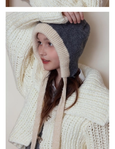 Close-up of contrast knit beanie showing dark grey and beige ribbing and side ear flaps