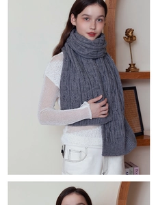 Detailed close-up showing the dark grey cable knit pattern and soft texture of the thick scarf