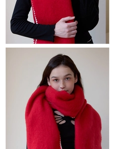 Detail of red mohair knit scarf showing soft fluffy texture and white zigzag edge stitching