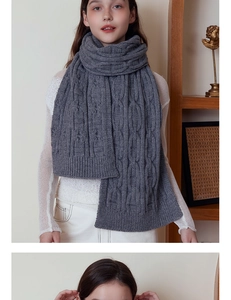 Detailed view of dark grey chunky cable knit scarf with thick wool texture and ribbed edges