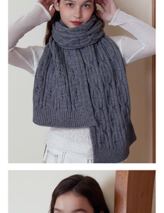 Detailed view of dark grey chunky cable knit scarf showing thick wool texture and pattern