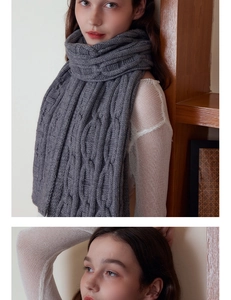 Close-up of gray cable-knit scarf showing thick wool texture and warm winter style