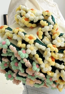 Detail of 3D crochet roses and flowers on a cozy cream knit handmade blanket
