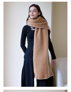 Detail of camel wool scarf featuring white embroidered scalloped edge stitching