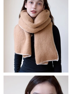 Detail of camel knitted scarf featuring white zigzag stitching and thick thermal texture