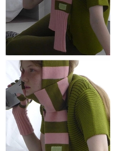 Détail d'une écharpe en tricot à rayures rose et olive avec gants sans doigts