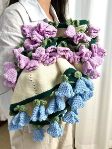 Detail of handmade knit floral blanket with 3D lavender and blue lily of the valley flowers