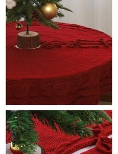 Close-up of red cable knit Christmas tree skirt with thick yarn texture and bow detail