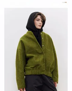 Close-up of silver floral buttons and moss green textured knit fabric on a winter jacket