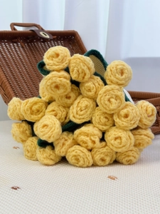 Detail view of handmade crochet rose bouquet with intricate yarn texture in picnic setting