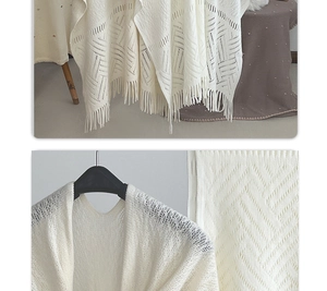 Detailed view of beige knit shawl featuring hollow crochet wave patterns and tassel trim