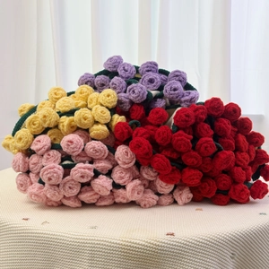 Detail of colorful handmade crochet rose bouquet on textured white knitted background
