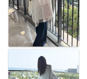 Detailed view of white hollow-out knit shawl with tassel hem and geometric texture