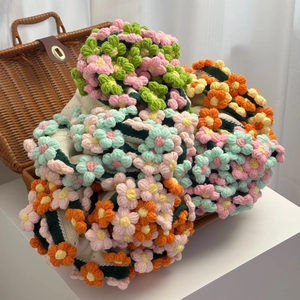 Handmade crochet floral blanket featuring 3D knitted flowers in vibrant pastel colors