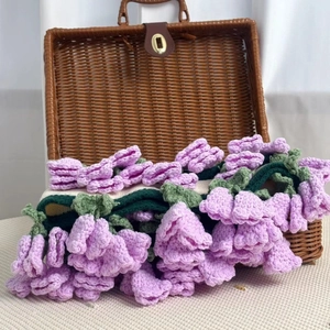 Detailed crochet lavender flowers in a brown wicker basket on a clean white background