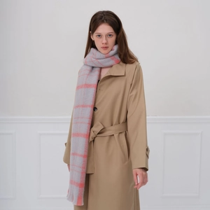 Écharpe à carreaux épaisse en gris et rose corail avec franges sur un mannequin femme
